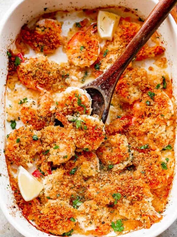 Spooning out shrimp from a baking dish.