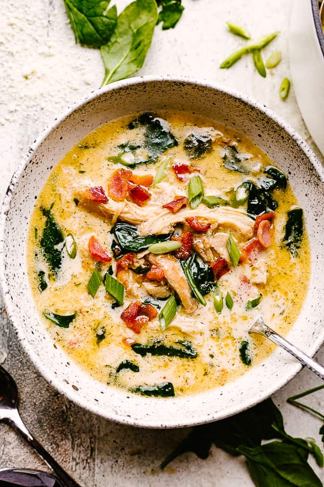 crack chicken soup in a bowl topped with bacon and green onions