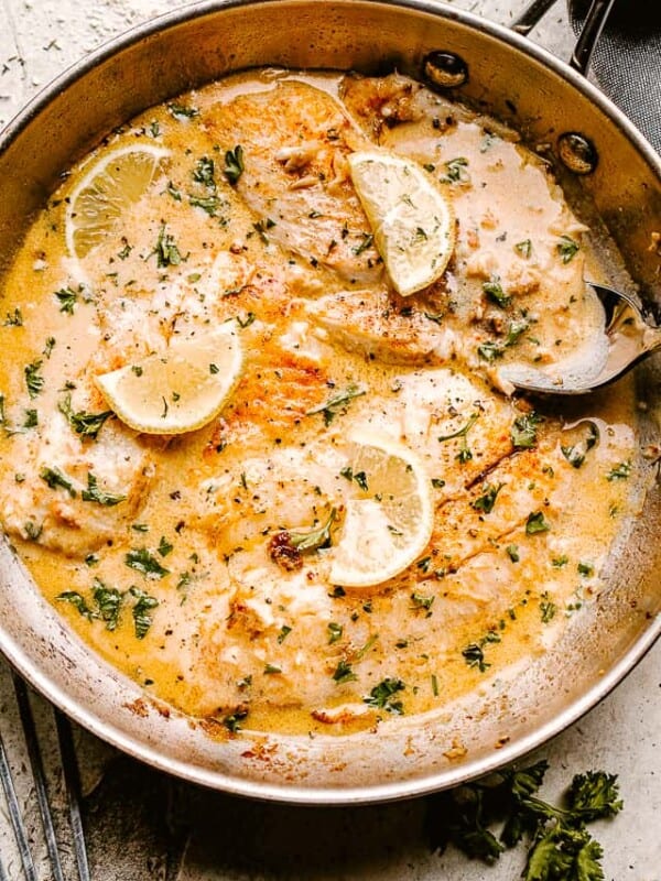 Pan fried tilapia filets in cream sauce, and garnished with lemon slices.