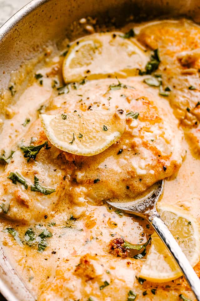 scooping out tilapia from the skillet.