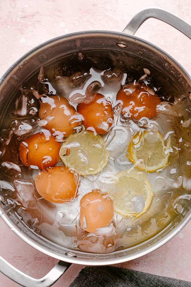 cooling boiled eggs in a pot with ice water