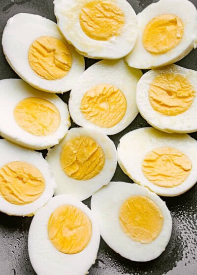 boiled eggs cut in half and set on a black plate