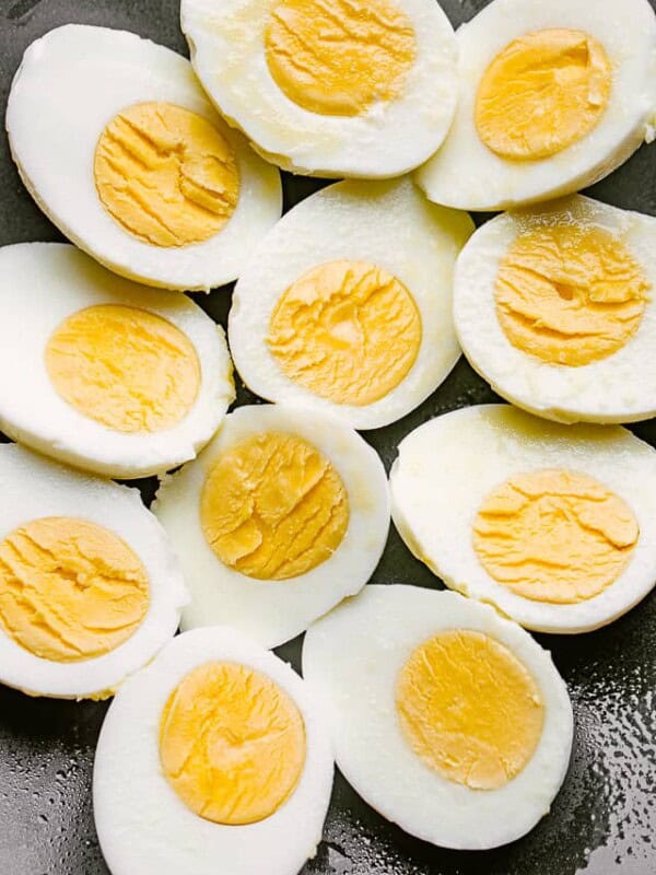 boiled eggs cut in half and set on a black plate