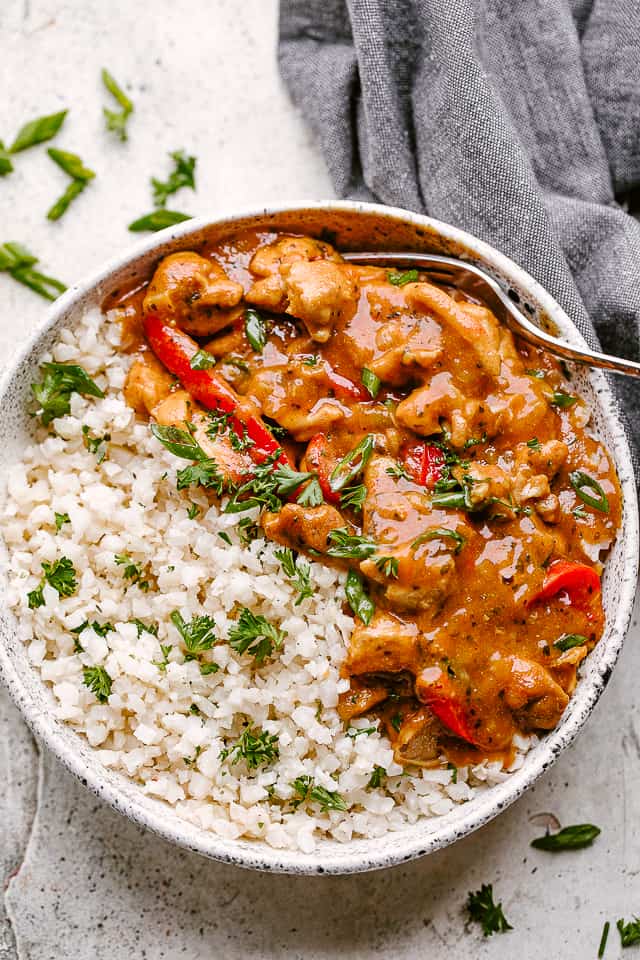 Instant Pot Coconut Chicken Curry Served in a bowl with a side of cauliflower rice.