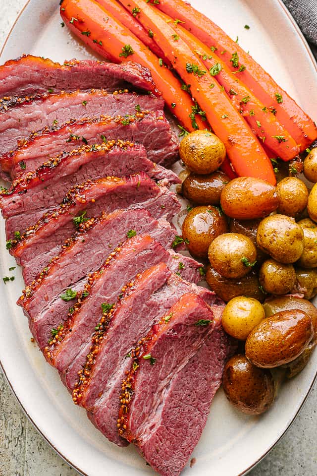 Crock Pot corned beef sliced and served with potatoes and carrots