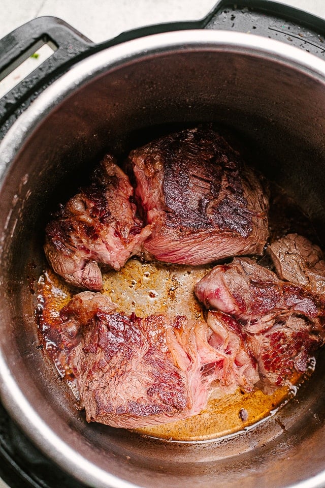 Searing chunks of chuck roast beef inside the Instant Pot.