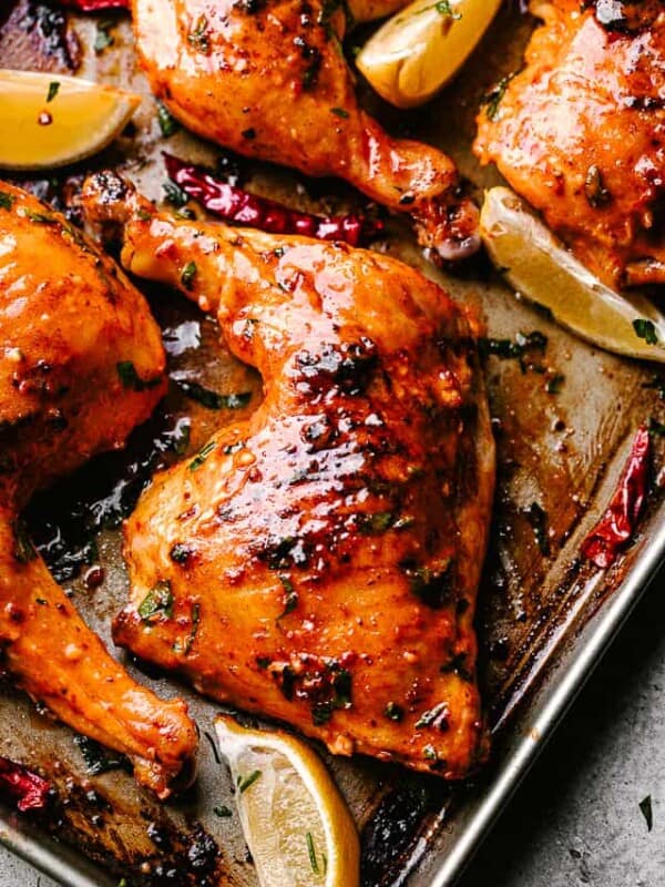 Piri Piri Chicken out of the oven and garnished with lemon wedges.