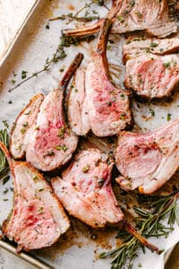 Roasted rack of lamb sliced and garnished with fresh rosemary.