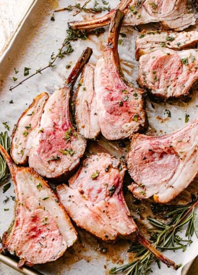 Roasted rack of lamb sliced and garnished with fresh rosemary.