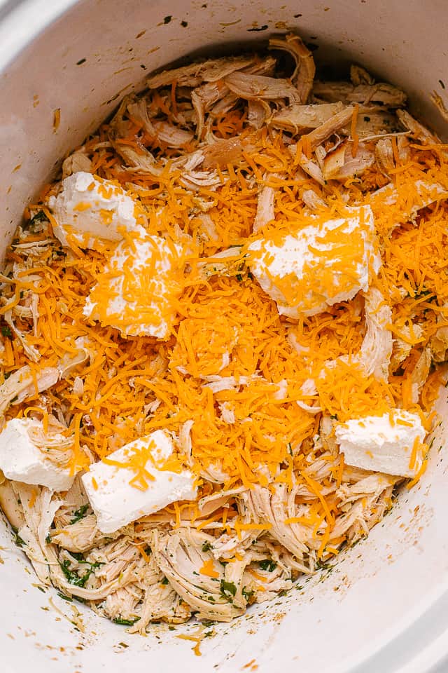Cheddar cheese, cream cheese, ranch seasoning and chicken in a slow cooker