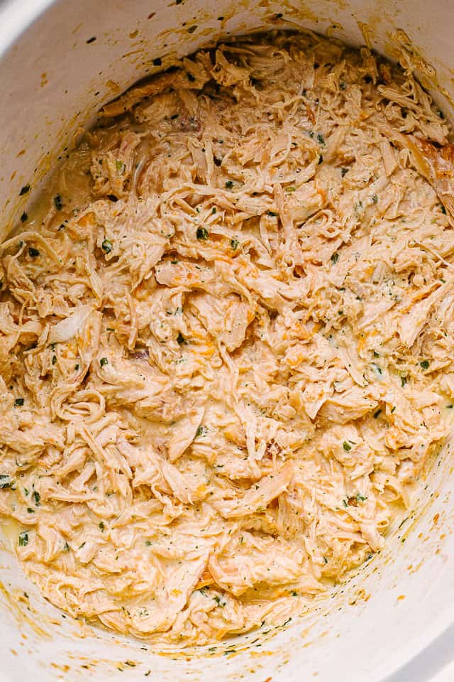 Cooked and shredded chicken in a pot.
