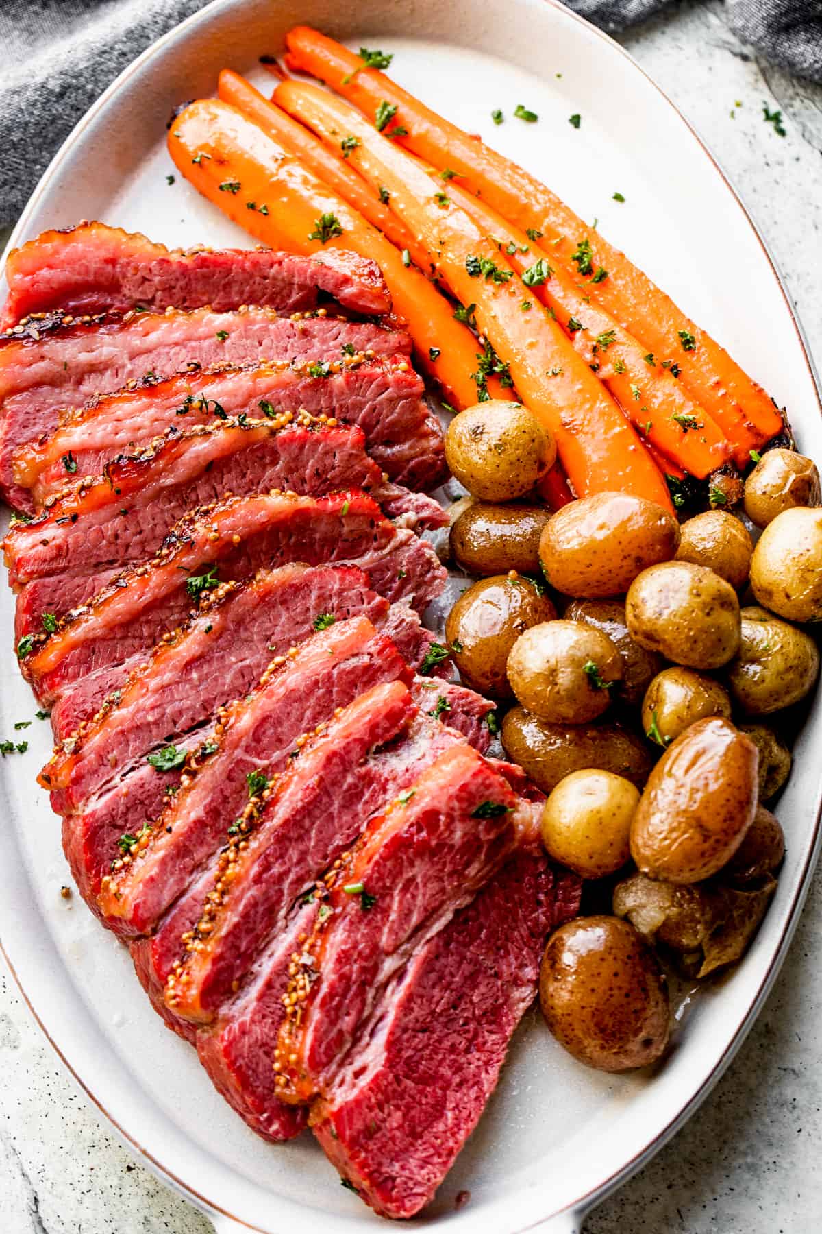 Crock Pot corned beef sliced and served with potatoes and carrots.