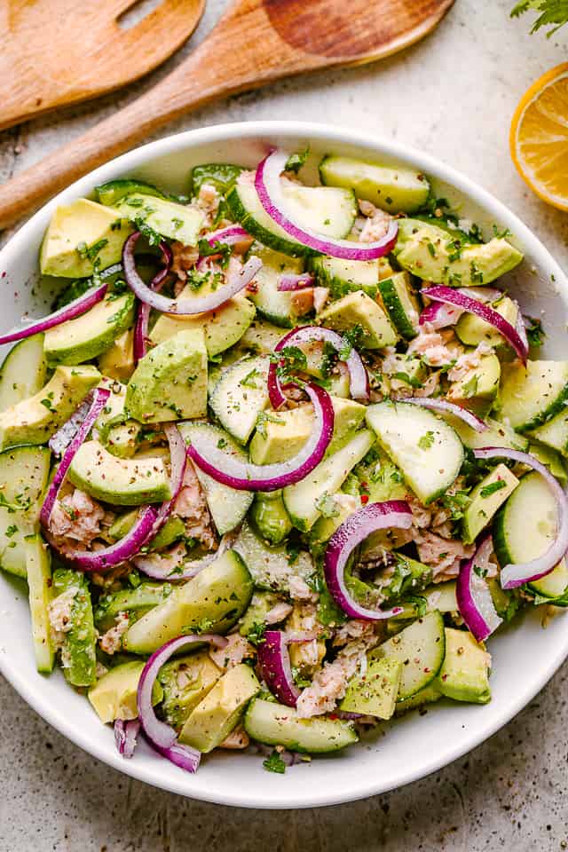 serving tuna avocado salad in a white bowl