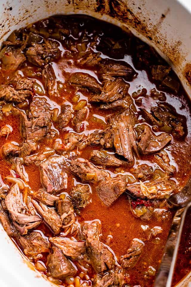 Cooked beef barbacoa in the slow cooker.