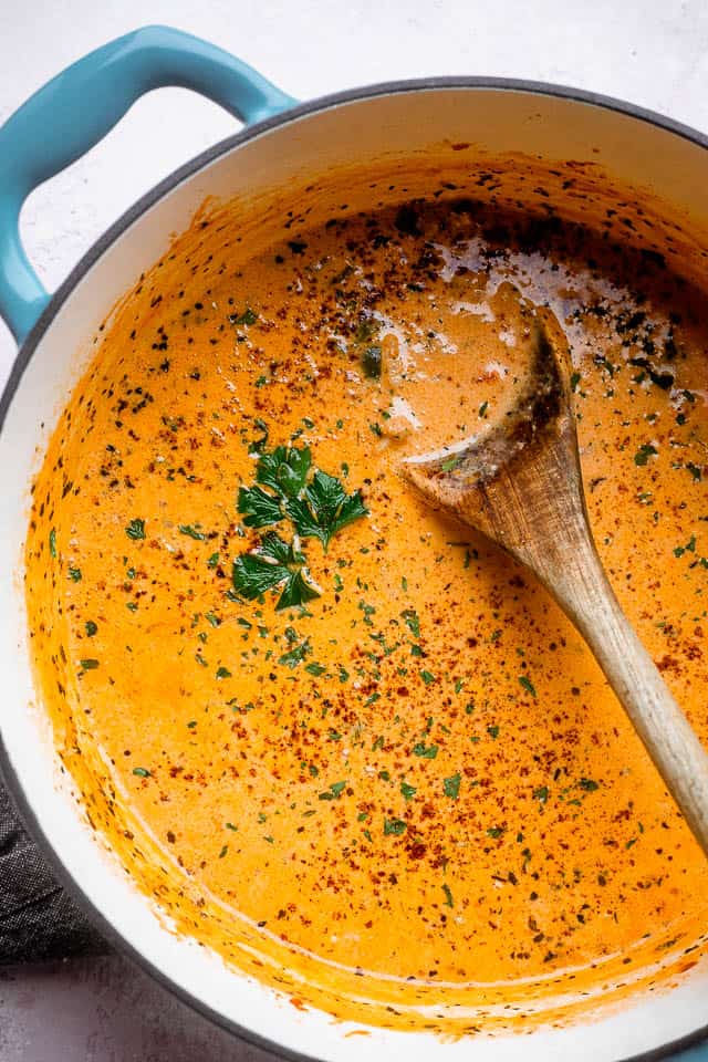 wooden spoon in a dutch oven filled with cheeseburger soup