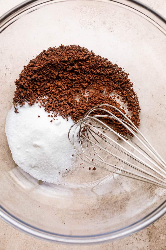 whisking sugar, coffee, and water in a glass mixing bowl