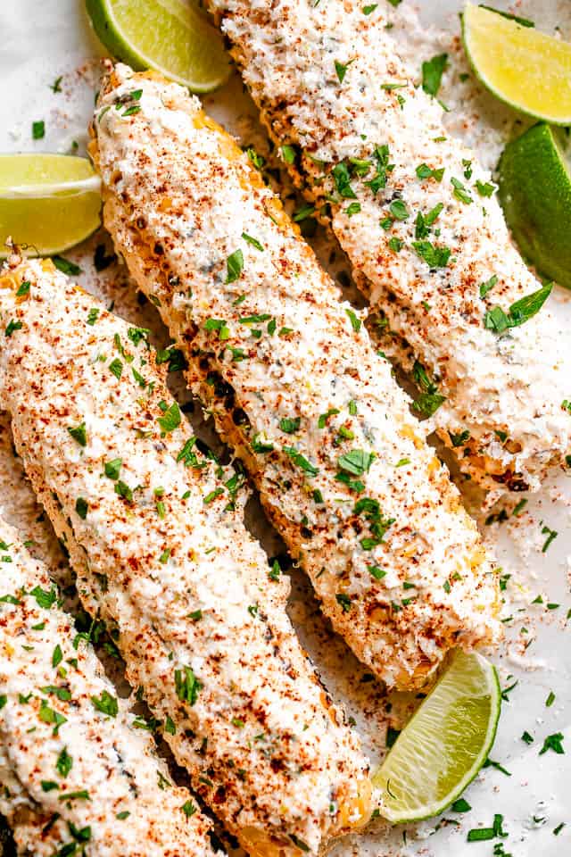 Ears of corn smothered with mayonnaise and dusted with chile powder.