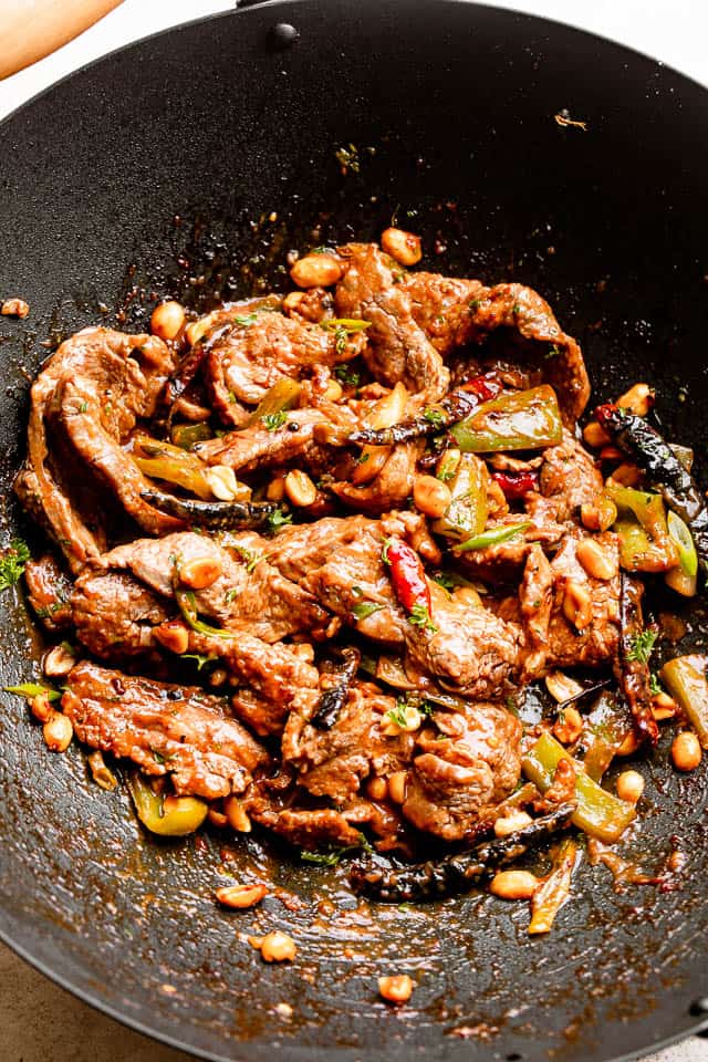 stir frying strips of beef in a black wok