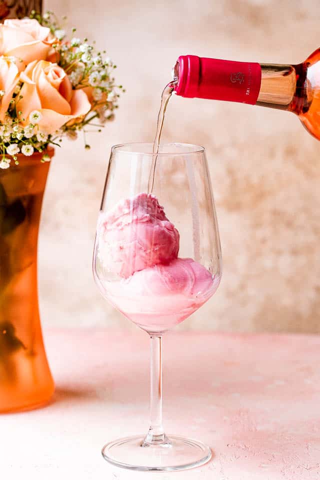 pouring rosé in a glass over scoops of sorbet