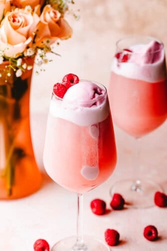 rose floats in wine glasses topped with sorbet and raspberries