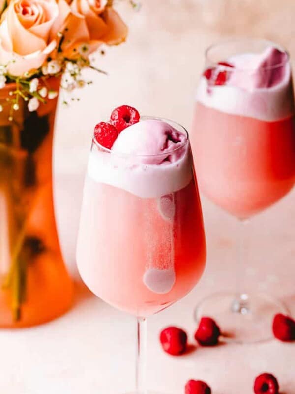 rose floats in wine glasses topped with sorbet and raspberries