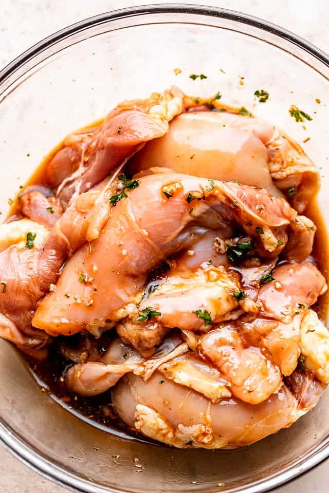 Raw chicken thighs marinating in honey soy sauce.