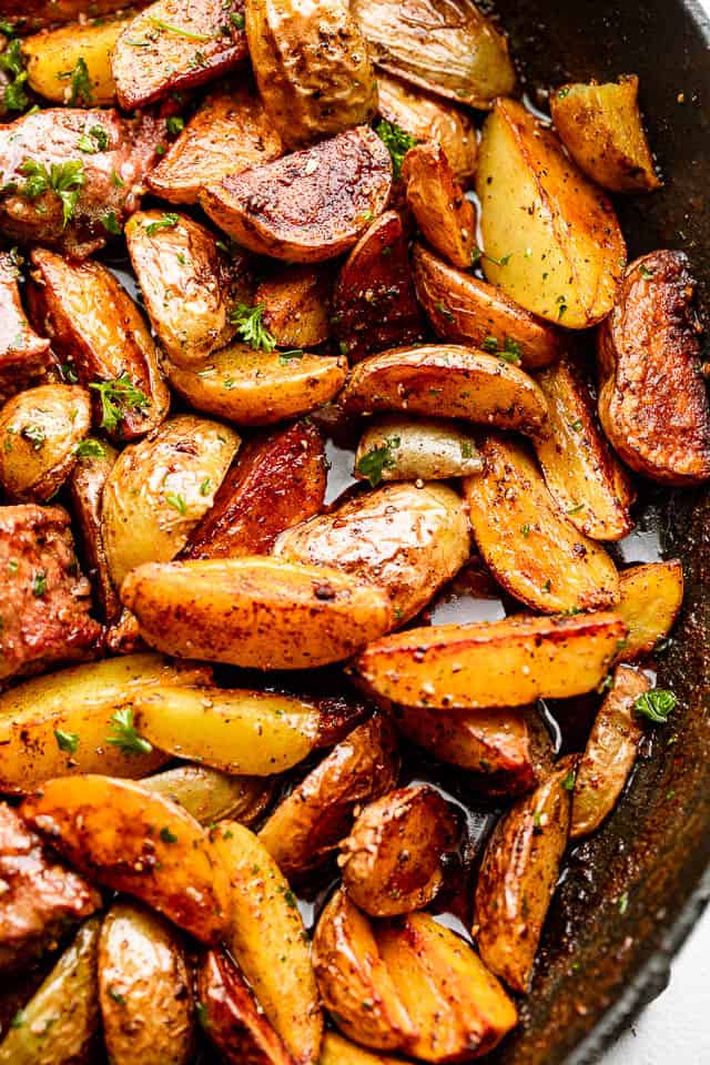 quartered yukon potatoes cooking in a skillet