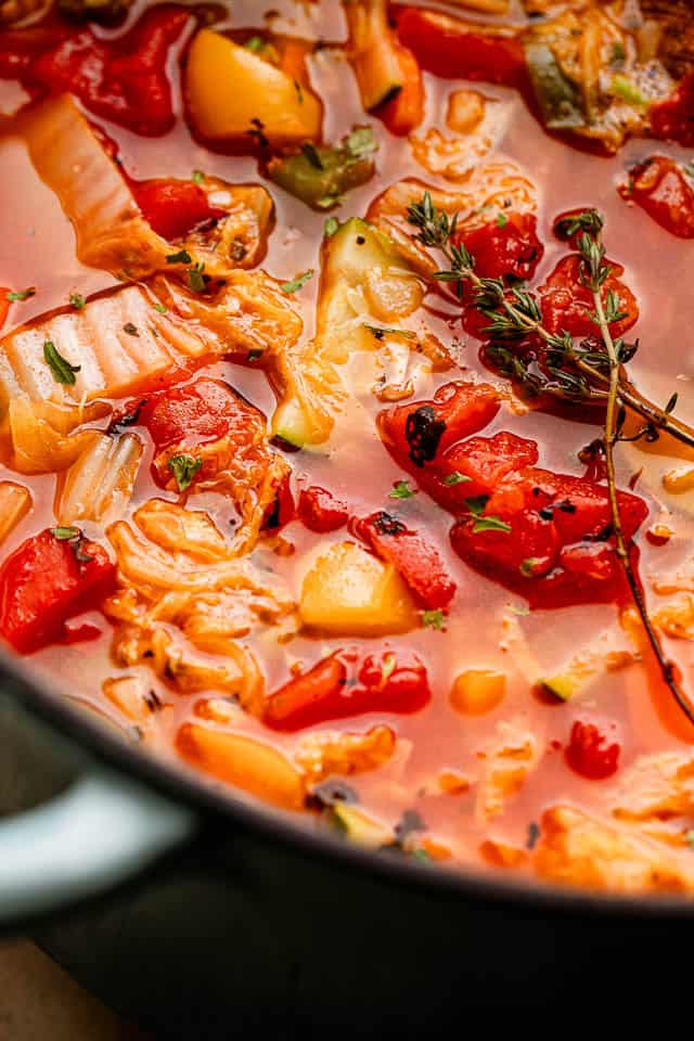 This easy cabbage soup recipe is packed with tender veggies simmered in a flavorful tomato broth. It’s hearty, delicious, and ready in 30 minutes! Close-up of cabbage soup cooking in a pot.