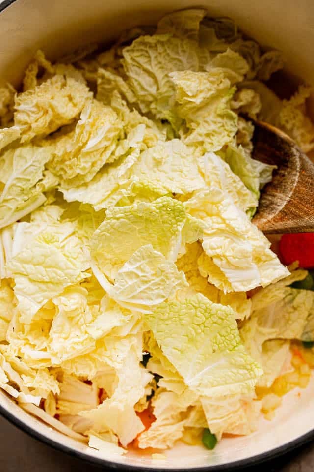 This easy cabbage soup recipe is packed with tender veggies simmered in a flavorful tomato broth. It’s hearty, delicious, and ready in 30 minutes! Chopped cabbage added to a pot of sautéed vegetables while making cabbage soup.