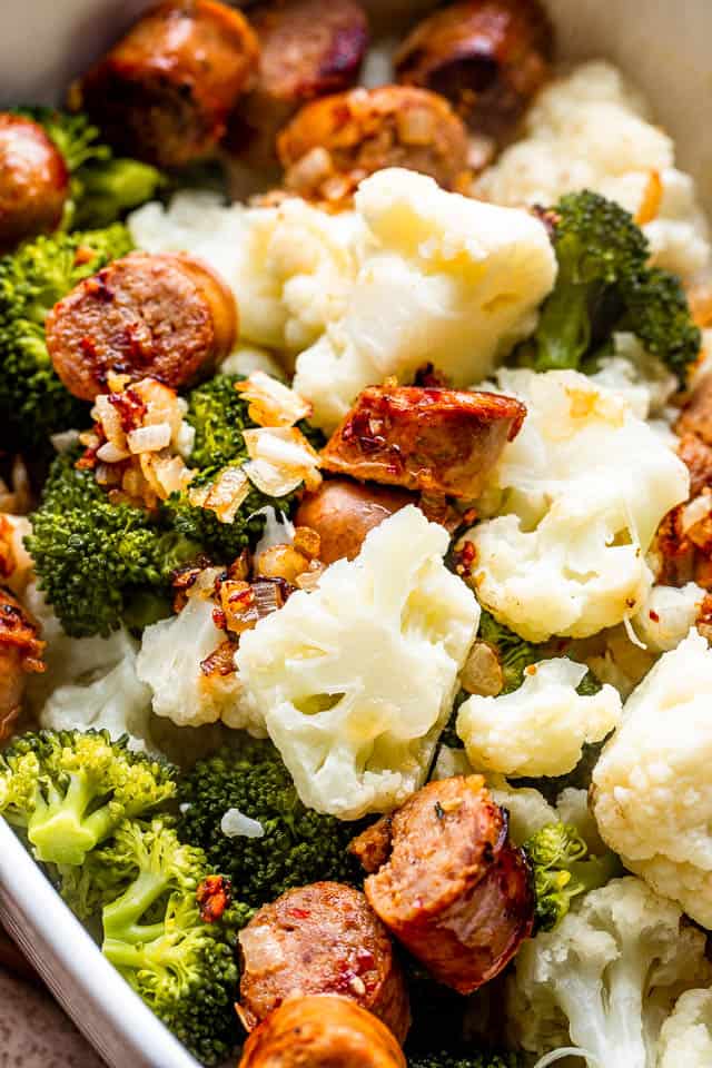 a mix of smoked sausage, cauliflower, and broccoli florets in a baking dish