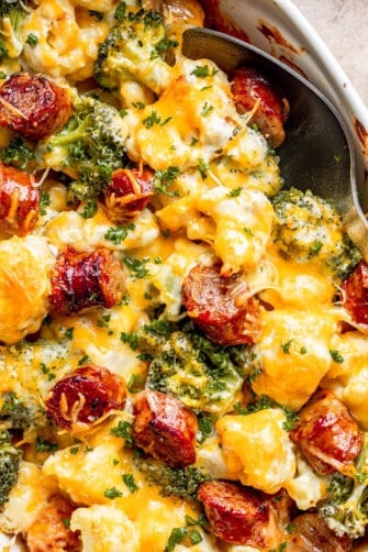 close up view of cauliflower broccoli casserole with sliced smoke sausages and cheese