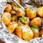 Halved baby yukon potatoes arranged in a foil pack.