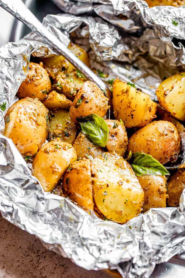 Halved baby potatoes in a foil packet.