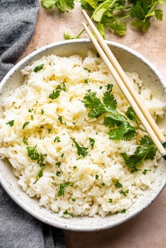 top view of instant pot cooked jasmine rice served in a bowl and topped with cilantro leaves