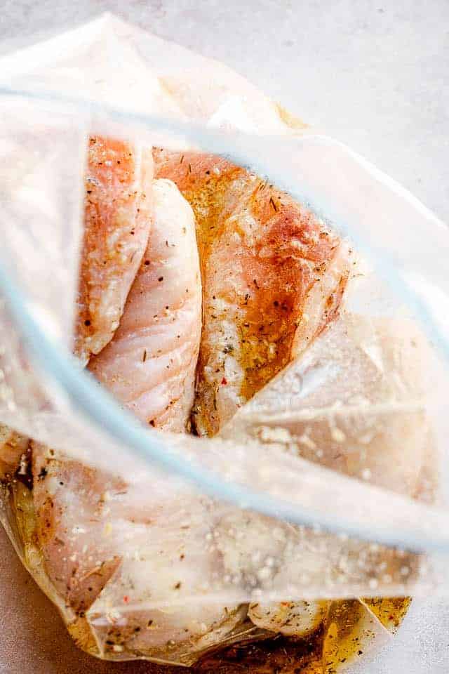 raw chicken breasts in a resealable bag with lemon marinade