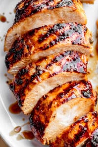 sliced chicken breast with grill marks set on a white plate