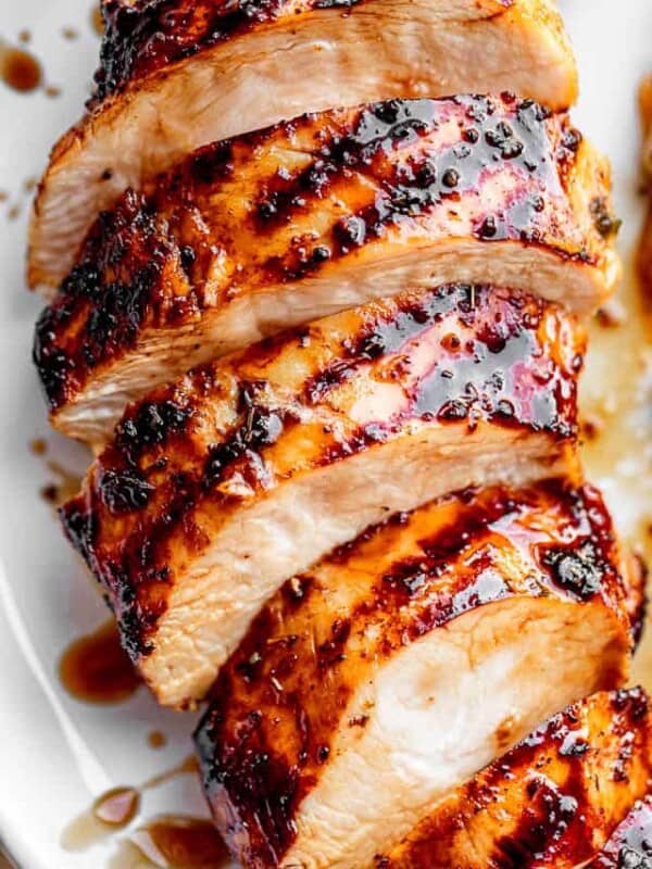sliced chicken breast with grill marks set on a white plate