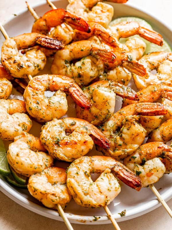 Grilled shrimp threaded onto skewers and arranged on a plate.