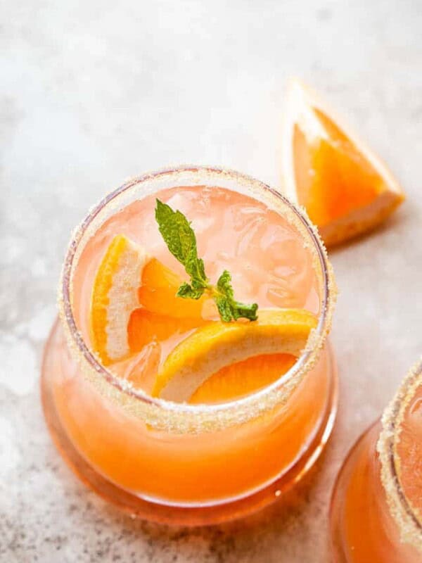 above shot of a drinking glass filled with a grapefruit rum cocktail, and garnished with mint leaves and grapefruit slices