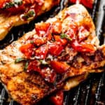 grilled mahi mahi steaks on a grill pan topped with a balsamic tomato salad