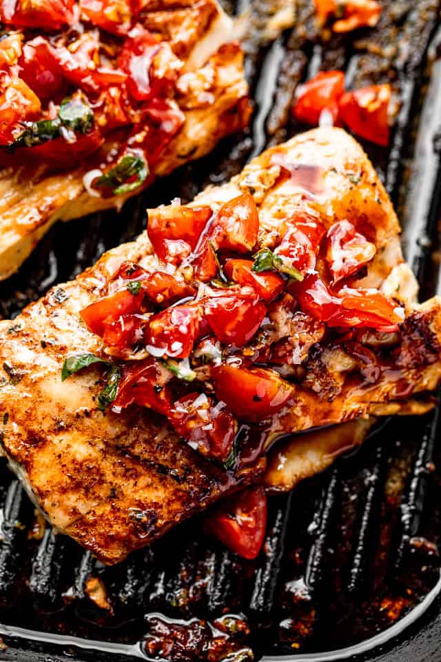 grilled mahi mahi steaks on a grill pan topped with a balsamic tomato salad