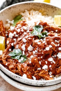 Chicken Mole served in a bowl with rice and sprinkled with cheese and cilantro