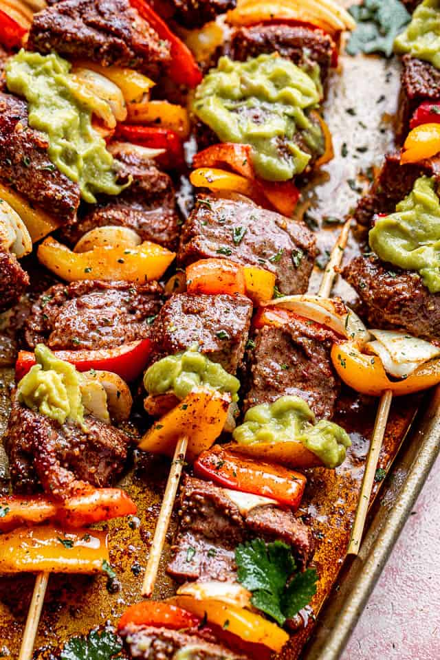 side view of grilled steak kabobs topped with guacamole