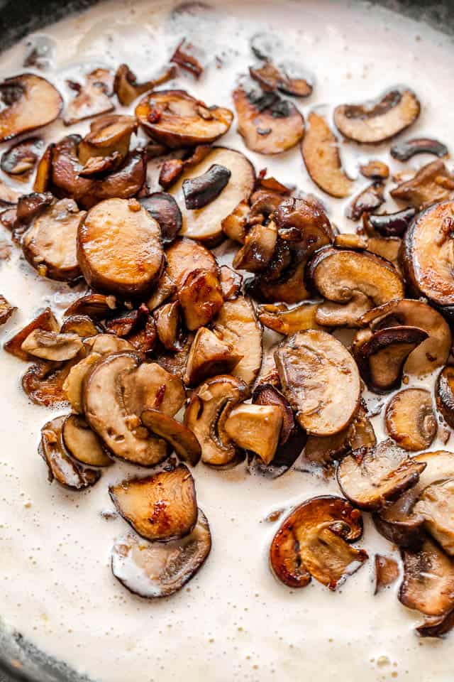 slices of cooked mushrooms in a white gravy sauce