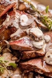 sliced beef tenderloin topped with mushrooms and gravy