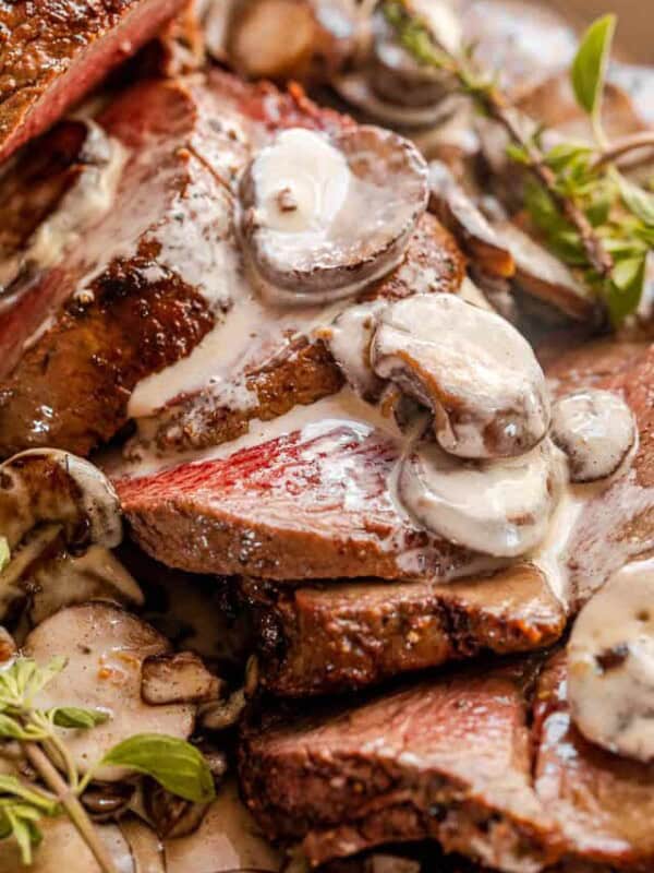 sliced beef tenderloin topped with mushrooms and gravy