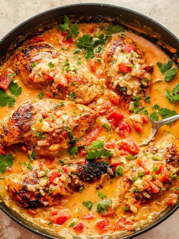 coconut milk chicken breasts in black skillet garnished with cilantro