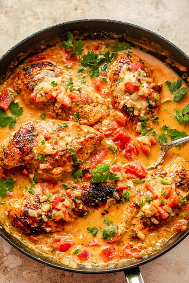 coconut milk chicken breasts in black skillet garnished with cilantro