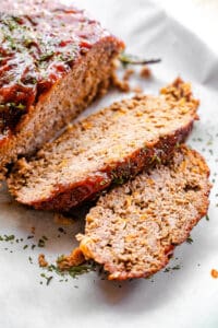 two meatloaf slices on a white backdrop