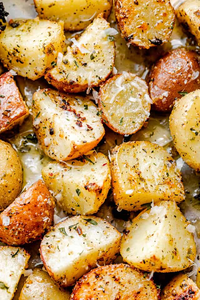 overhead shot of quartered baby potatoes air fried with herbs and butter and sprinkled with Parmesan cheese.